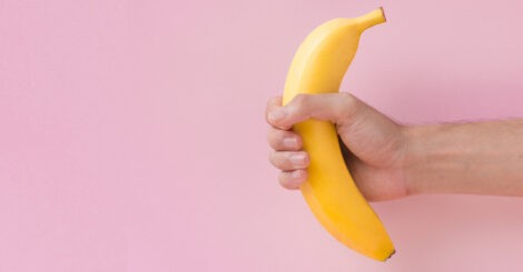 Mężczyzna trzyma banana w dłoni